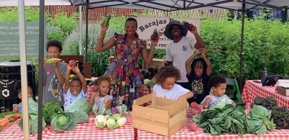 Families at a fresh produce market stand